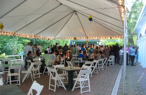 A party under the tented courtyard at The Governor's Inn, string lights overhead