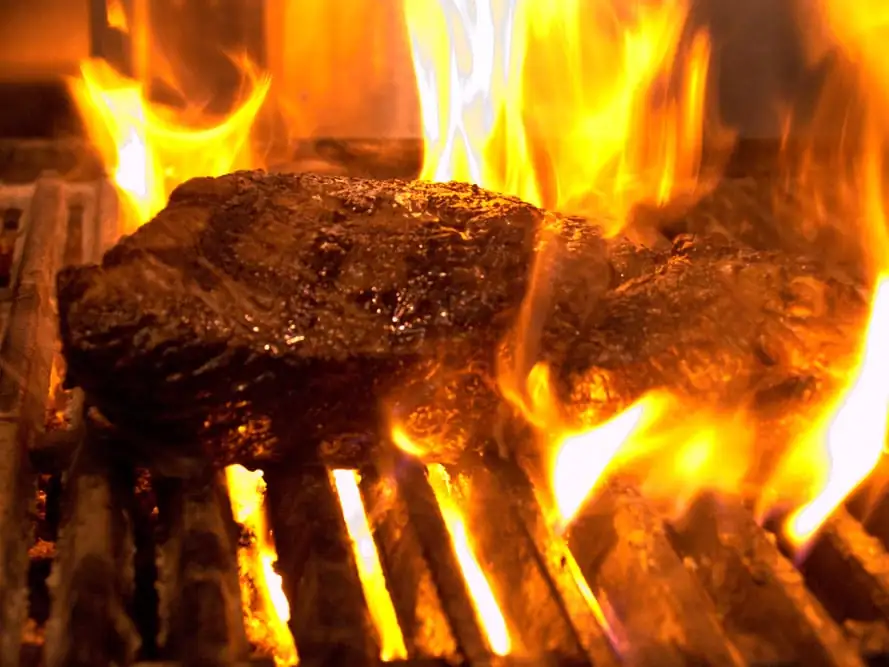 Steak tips flame-broiling over open fire in the Spaulding Steak & Ale kitchen